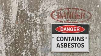 A sign on a wall that says DANGER: CONTAINS ASBESTOS | Kim Britten | Dreamstime.com