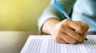 Close-up of a student's hand as they fill out a multiple-choice test. | Sengchoy2016 | Dreamstime.com