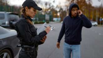 A female police officer writes a ticket for a male motorist. | Nomadsoul1 | Dreamstime.com