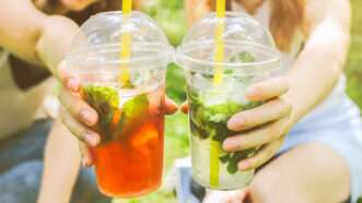 Two girls holding iced drinks outside | Photo 193210549 / Alcohol To Go © Vadym Plysiuk | Dreamstime.com