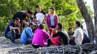 A group of Cuban migrants stand in the sun after arriving in the Florida Keys on January 2. | Pedro Portal/TNS/Newscom